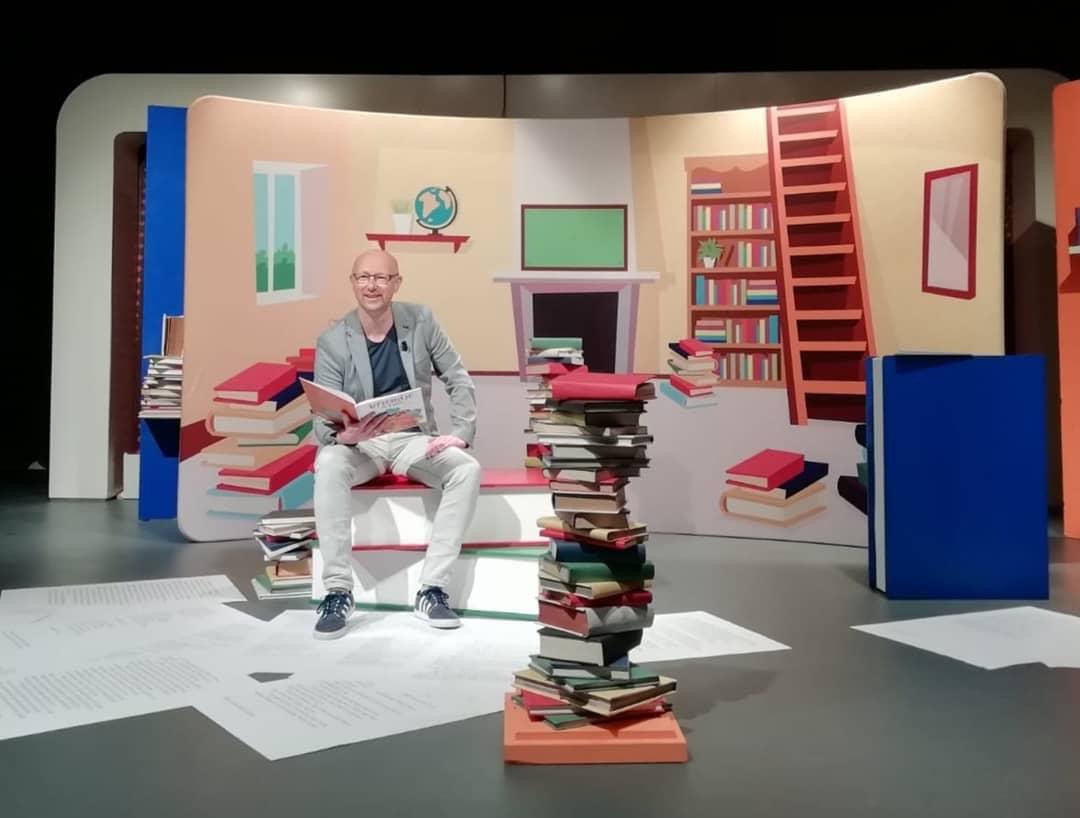 Bram Kasse op een stapel boeken